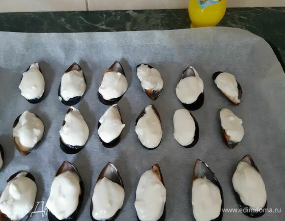 Выкладываем чайной ложкой соус на мидии и выкладываем на противень. Ставим в предварительно разогретую до 200°C духовку и запекаем при 210–220°C 15 минут.