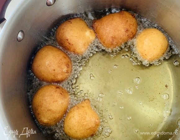 Опустить шарики в горячее масло и обжарить до золотистого цвета. Огонь должен быть чуть выше среднего, чтобы пончики полностью пропеклись изнутри.