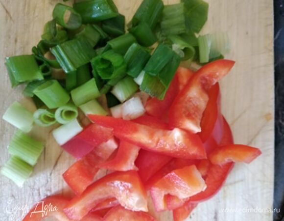Тем временем нарезать соломкой болгарский перец и некрупно — зеленый лук.