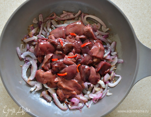 Затем добавьте к луку печень и мелко нарезанный острый перец. Количество острого перца регулируйте по вкусу. Я использовала острый перец чили и добавила его совсем немного. Жарьте печень с луком 2 минуты, аккуратно перемешивая.