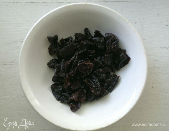 Чернослив промыть в горячей воде. Если он очень жесткий, замочить на 5–10 минут в кипятке. Затем воду слить, обсушить чернослив бумажным полотенцем и нарезать на мелкие кусочки.