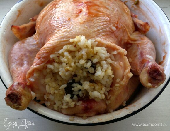 Маринованную курицу достать из холодильника, начинить рисом с черносливом.