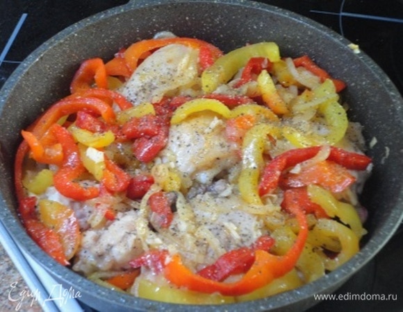 Добавить лук и хорошо перемешать. Тушить еще 2 минуты. Добавить чеснок, перемешать и выложить между перцами кусочки подрумяненной курицы. Поставить блюдо в разогретую духовку и готовить 20–25 минут.