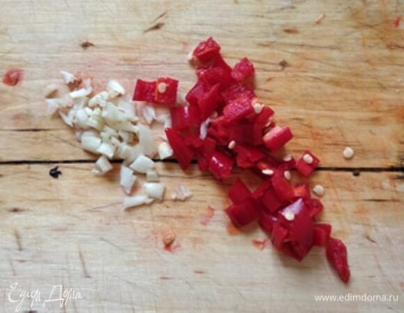 Отварить пасту согласно инструкции на упаковке. Пока паста готовится, делаем соус. Мелко нарезать перец чили. По рецепту семена нужно удалить. Я люблю острое, поэтому не удаляла. Мелко порубить чеснок. В сковороде разогреть оливковое масло и обжарить чеснок и перец около 3 минут.