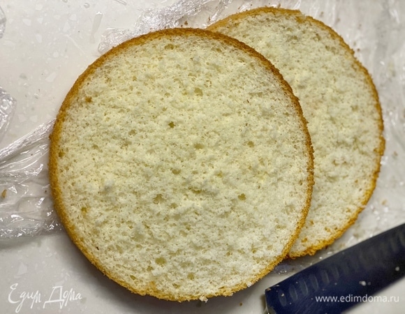 Готовый бисквит охладить и разрезать на 2 части.