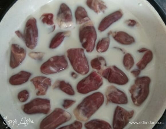 Сердечки избавить от жира и остатков крови и сосудов. Для этого можно надрезать посередине и промыть. Сложить в миску и залить молоком. Оставить на час.
