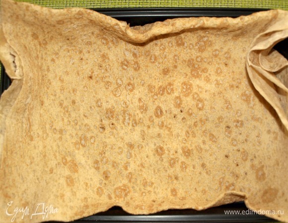 Один пласт тонкого лаваша складываем в несколько раз. Выстилаем противень для запекания, чтобы получились бортики.