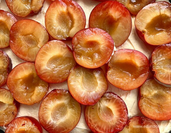 Сливы промойте, разрежьте на половинки. Разрезайте по видимому шву, так легче будет доставать косточки. Выложите сверху на тесто, слегка вдавливая.