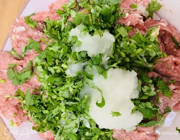 В мясной фарш добавить измельченную зелень, протертый лук и остальные специи. Перемешать до однородности.
