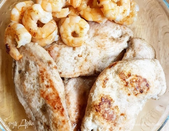 Промываем куриное филе. Разрезаем вдоль по длине пополам. Укладываем в тару, посыпаем молотым имбирем, кладем ложку карри, сбрызгиваем кунжутным маслом, посываем перцем. Перемешиваем. Даем курице напитаться маринадом около 15 минут. Разогреваем сковороду, сбрызгиваем маслом. На сильном огне по две минуты с каждой стороны обжариваем куриное филе, затем еще держим около 3 минут до готовности, переворачивая. На этом же масле около минуты-полторы до румяной корочки обжариваем креветки. Убираем филе и креветки на салфетку.