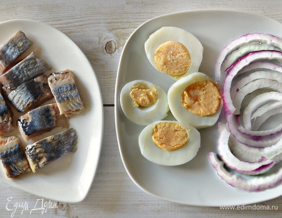 Подготовить филе малосоленой сельди. Красный лук нарезать полукольцами. Яйцо — кружочками.