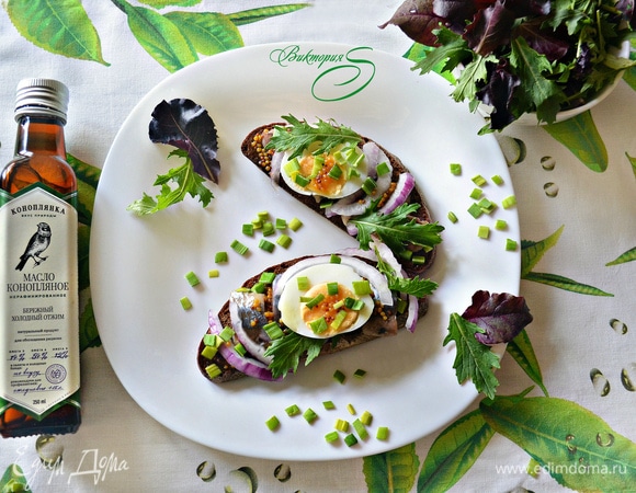 На каждый кусок хлеба положить по 4 кусочка сельди, 1–2 кружочка нарезанного яйца, красный и зеленый лук. Полить соусом. Украсить салатным миксом и тут же подавать! Приятного вам аппетита!