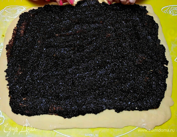 Раскатать тесто, разделить маковую начинку на две части и распределить ее по тесту.