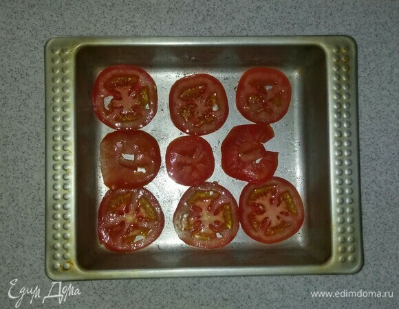 Помидор нарезать кружками. Выложить на дно формы для запекания и посолить.