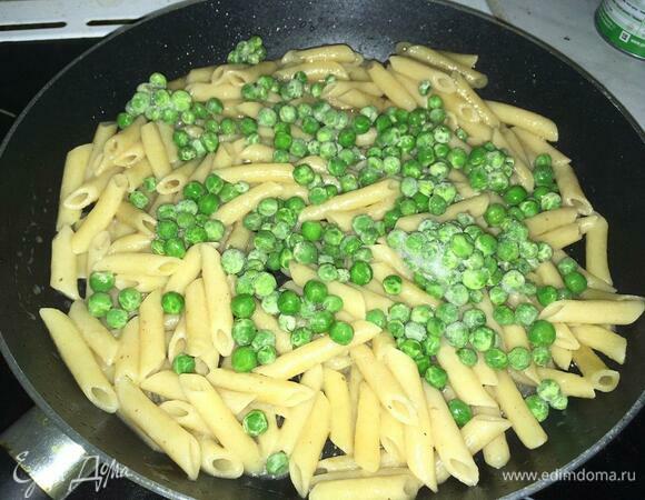Добавляем к макаронам замороженный зеленый горошек, еще тушим под закрытой крышкой две минуты, чтобы с горошка ушел лед.