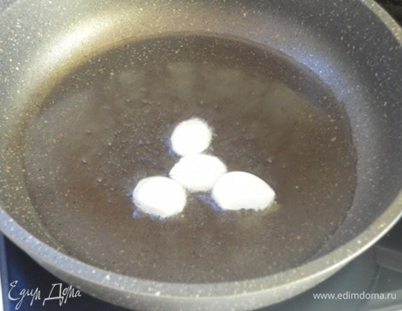 Лук нарежьте полукольцами или кольцами, чеснок — на 2–3 части. Сковороду с маслом хорошо нагрейте и обжарьте зубчики чеснока.