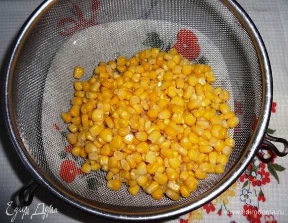 Консервированную кукурузу выложить на дуршлаг, чтобы стекла жидкость.