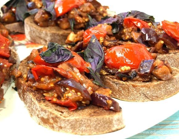 На хлеб выкладываем овощи, сверху добавляем свежий базилик. Опционально посыпаем сыром. Можно подавать к столу.