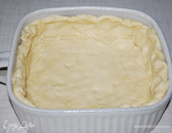 Форму для выпечки смазать маслом. Тесто разделить на 2 части. Тесто выложить в форму.