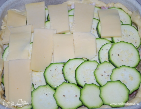 На кабачок выложить сыр, нарезанный полосками.