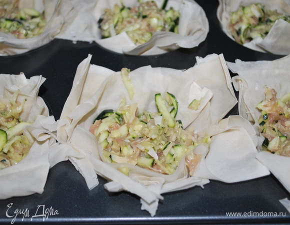 Форму для выпечки смазать маслом (у меня форма для крупных кексов, 6 шт.) Тесто фило разрезать на квадраты и выложить в формы. Заполнить тесто начинкой.