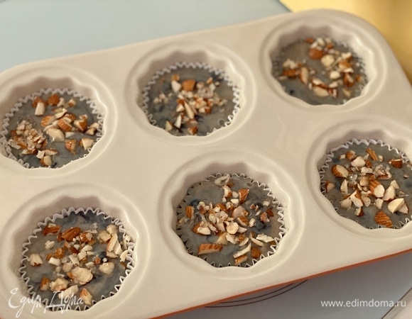 Разложить тесто в формы ложкой, заполнив их до самого верха (!). Сверху выложить порубленные любимые орехи, смешанные с сахаром. Выпекать 5 минут при 220°C, далее снизить до 175°C, выпекать еще 18–20 минут.