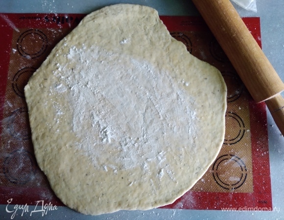 Духовку разогреть до 190°C. Охлажденное тесто раскатать в круг (если нужно, посыпать мукой). Делайте это сразу на коврике или бумаге. Посыпать крахмалом.