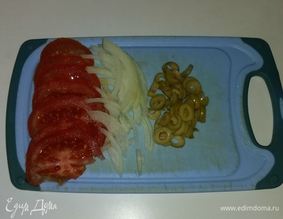 Репчатый лук разрезать пополам. И одну половину лука нарезать полукольцами, а затем «распушить» руками. Один помидор нарезать тонкими дольками. Оливки нарезать кружочками.