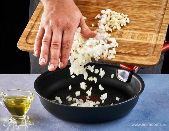 Приготовьте соус. Для этого нарежьте кубиком лук, а чеснок измельчите. Пассеруйте до золотистого цвета в растительном масле. 