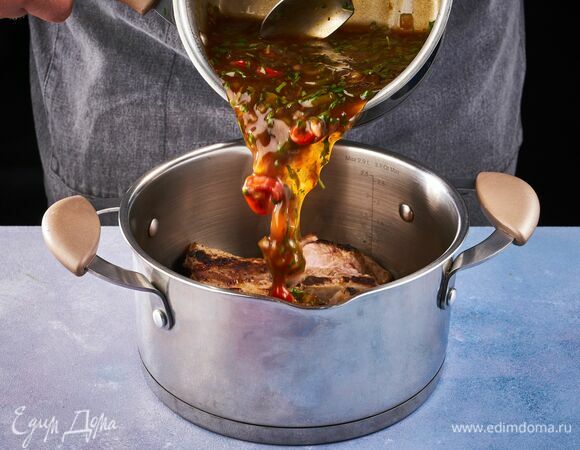 Переложите ребрышки в кастрюлю, залейте соусом и тушите под крышкой на медленном огне в течение часа. 