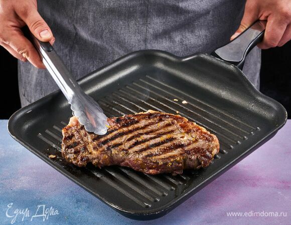 Выложите стейк на бумажные полотенца, как следует обсушите. Обжаривайте на высоком огне с добавлением оливкового масла по 3 минуты с каждой стороны. <br />
Остатки апельсинового маринада отдельно доведите до кипения пока соус не загустеет.