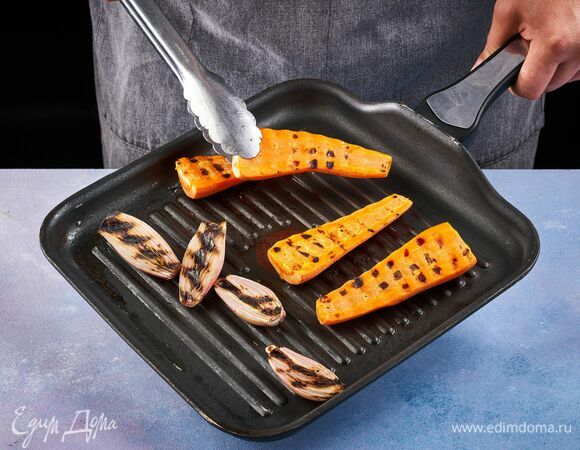 Разрежьте лук-шалот и морковь пополам. Положите срезом вниз на раскаленную сухую сковороду, обжарьте с двух сторон. 