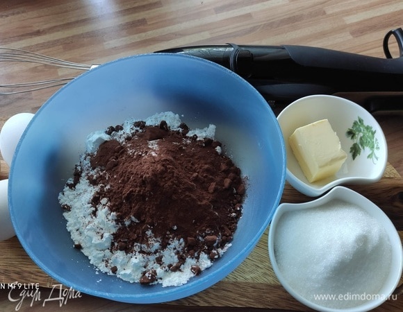 Для бисквита: отделить желтки от белков. Смешать муку с крахмалом и какао. Растопить сливочное масло. Духовку разогреть до 180°C (верх/низ), выстелить дно разъемной формы диаметром 26 см бумагой для выпечки.