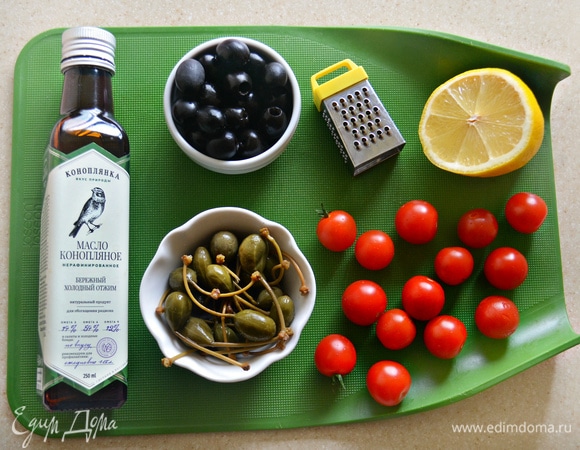 Подготовьте маслины, каперсы и помидоры черри. У каперсов удалите хвостики и разрежьте вдоль пополам, черри также разрежьте пополам.