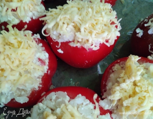 Начинить помидорки. Посыпать каждую тертым сыром и накрыть крышечками от помидоров. Духовку разогреть до 180°C.