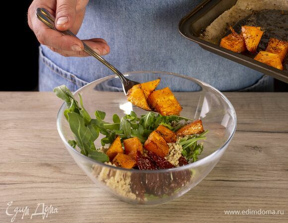 В глубокий салатник выложите киноа, запеченную тыкву, руколу и вяленые томаты.
