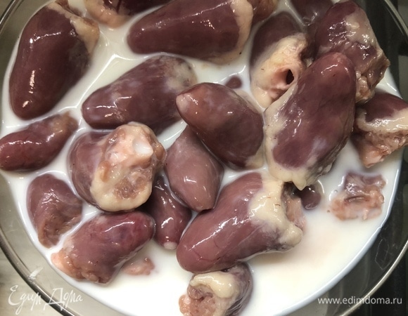 Сердечки замочите в молоке на пару часов, нарежьте пополам, удалив лишний жир и сгустки крови.