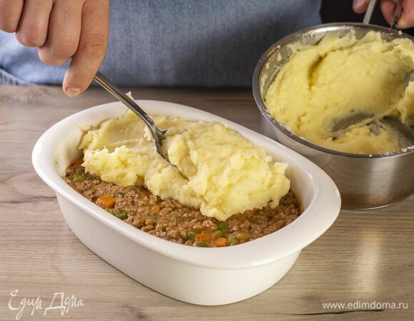 Обжаренное мясо с овощами выложите в форму для запекания. Сверху ровным слоем выложите пюре. Запекайте в духовке, разогретой до 180°С, около 20 минут.