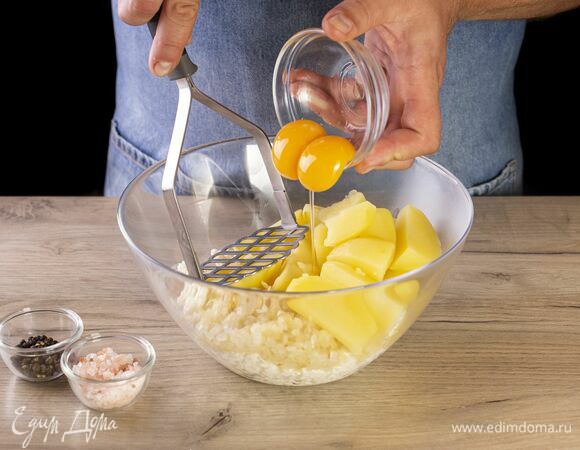 Добавьте отваренный картофель, желтки, соль, перец, хорошо перемешайте. Пропюрируйте все толкушкой.