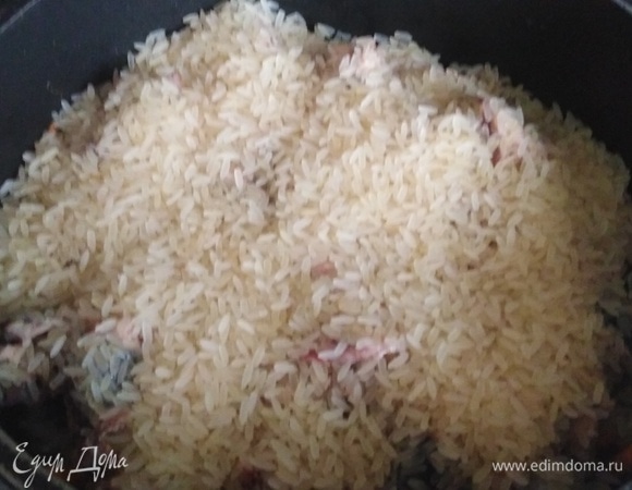 На рыбу выложить слоем промытый рис.