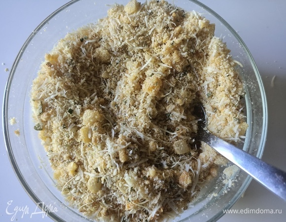 В миску насыпаем панировочные сухари, добавляем натертый сыр, кунжут, карри, соль и перец, перемешиваем. Шалфей, розмарин, лук и один зубчик чеснока мелко измельчаем, перемешиваем. 1/3 ароматных трав откладываем, остальную часть добавляем к панирочным сухарями и снова все хорошо перемешиваем.