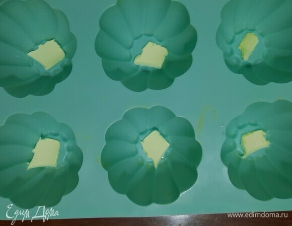 На дно формы для маффинов выкладываем кусочки масла, чтобы яблоки не подгорели.