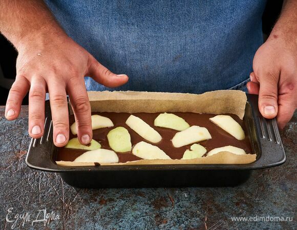 С яблока снимите кожуру и нарежьте дольками. Выложите их поверх теста. Запекайте в духовке при 180°C около 40 минут.