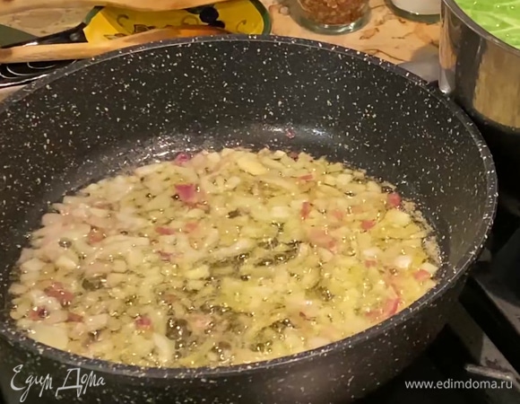 В тяжелой глубокой сковороде разогреть оливковое и сливочное масло и обжарить лук и чеснок до прозрачности.