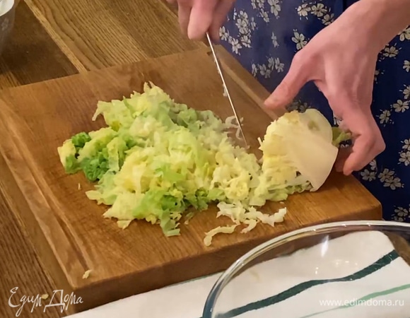 Капусту, удалив кочерыжку, нарезать небольшими кусочками, отжать бумажными полотенцами и выложить в сковороду к луку с чесноком, все посолить и немного прогреть.