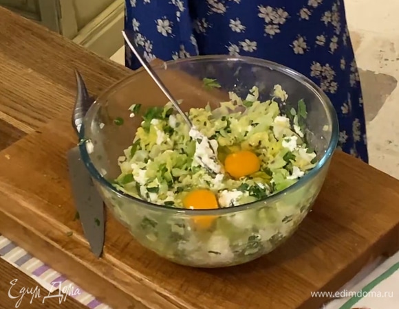 Выложить капусту в глубокую миску, добавить творог, 2 яйца и измельченную зелень, все посолить и перемешать.