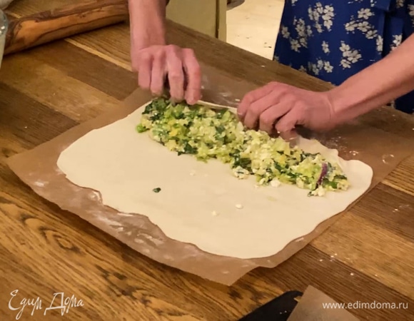 Тесто поместить на лист бумаги для выпечки, слегка присыпать мукой и раскатать в прямоугольный пласт, на одну сторону, отступив 1 см от края, выложить начинку и свернуть в рулет. Края теста по бокам штруделя подвернуть внутрь.