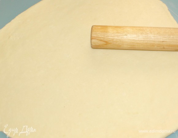 На припыленной мукой поверхности тонко раскатать тесто в виде круга.