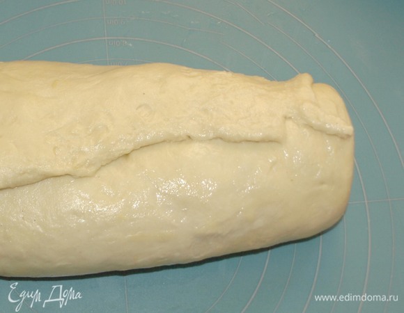 Сворачиваем тесто с начинкой в рулет, так чтобы край получился внахлест. Соединяем хорошо концы рулета. Края сбоку подгибаем внутрь.