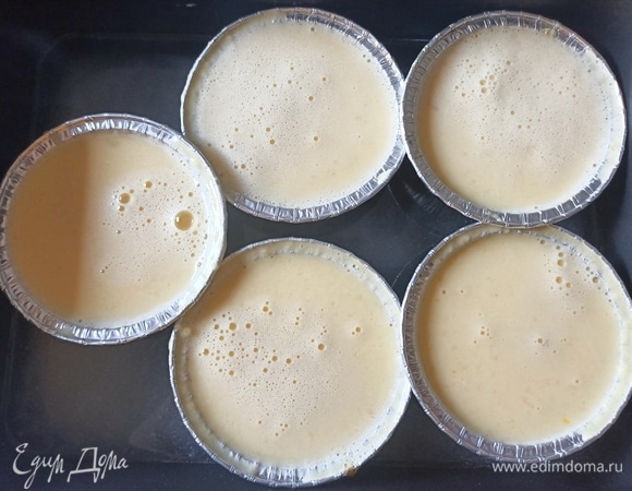 Заполняем формочки молочной-яблочной смесью. Ставим в небольшой противень и заливаем кипятком на 1/3 формы.